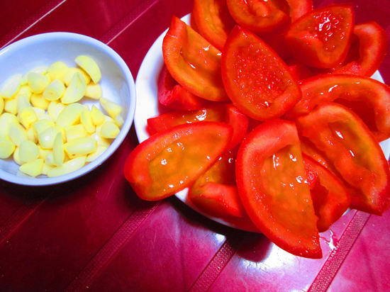 Cà chua đi rửa sạch rồi xắt làm tư, bỏ hạt. Tỏi bóc vỏ